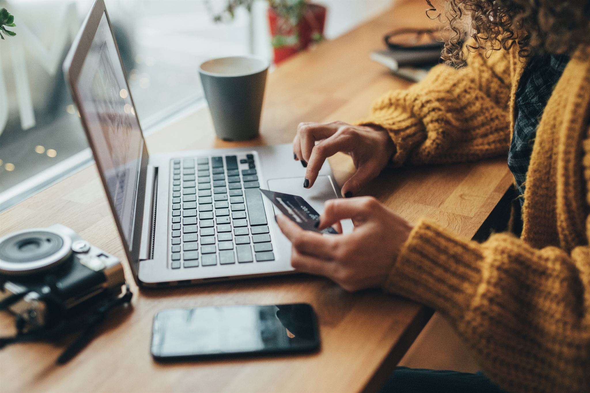 Person-holding-credit-card-using-laptop